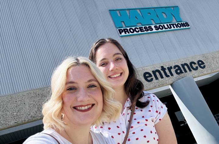 two women smiling outside the entrance to Hardy Solutions' office