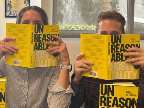 Madison and Brian holding Unreasonable Hospitality book