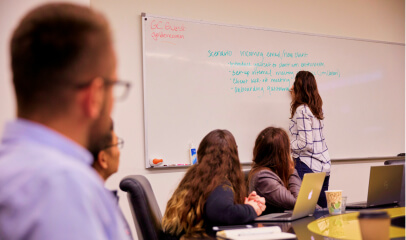 Team member writing on a whiteboard